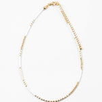 Dainty bead necklace made of white and gold beads.