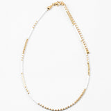 Dainty bead necklace made of white and gold beads.