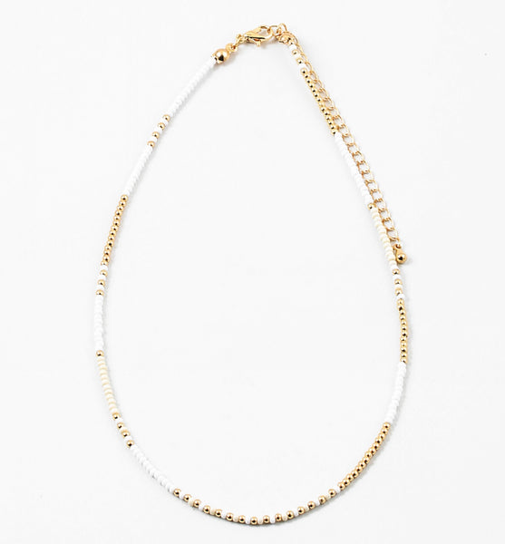 Dainty bead necklace made of white and gold beads.