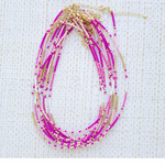 Screen shot of a stack of necklaces with pink and gold beads on a white background