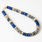 Chunky necklace with blue, gray and gold beads.