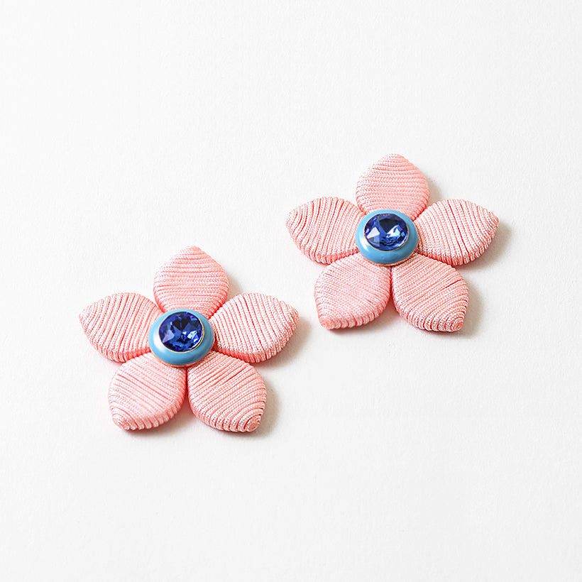 A pair of five petal earrings with a blue stone center.