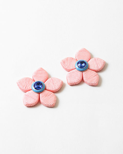 A pair of five petal earrings with a blue stone center.