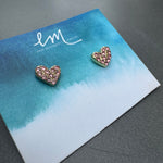 Heart-shaped earrings with pink stones on a branded card