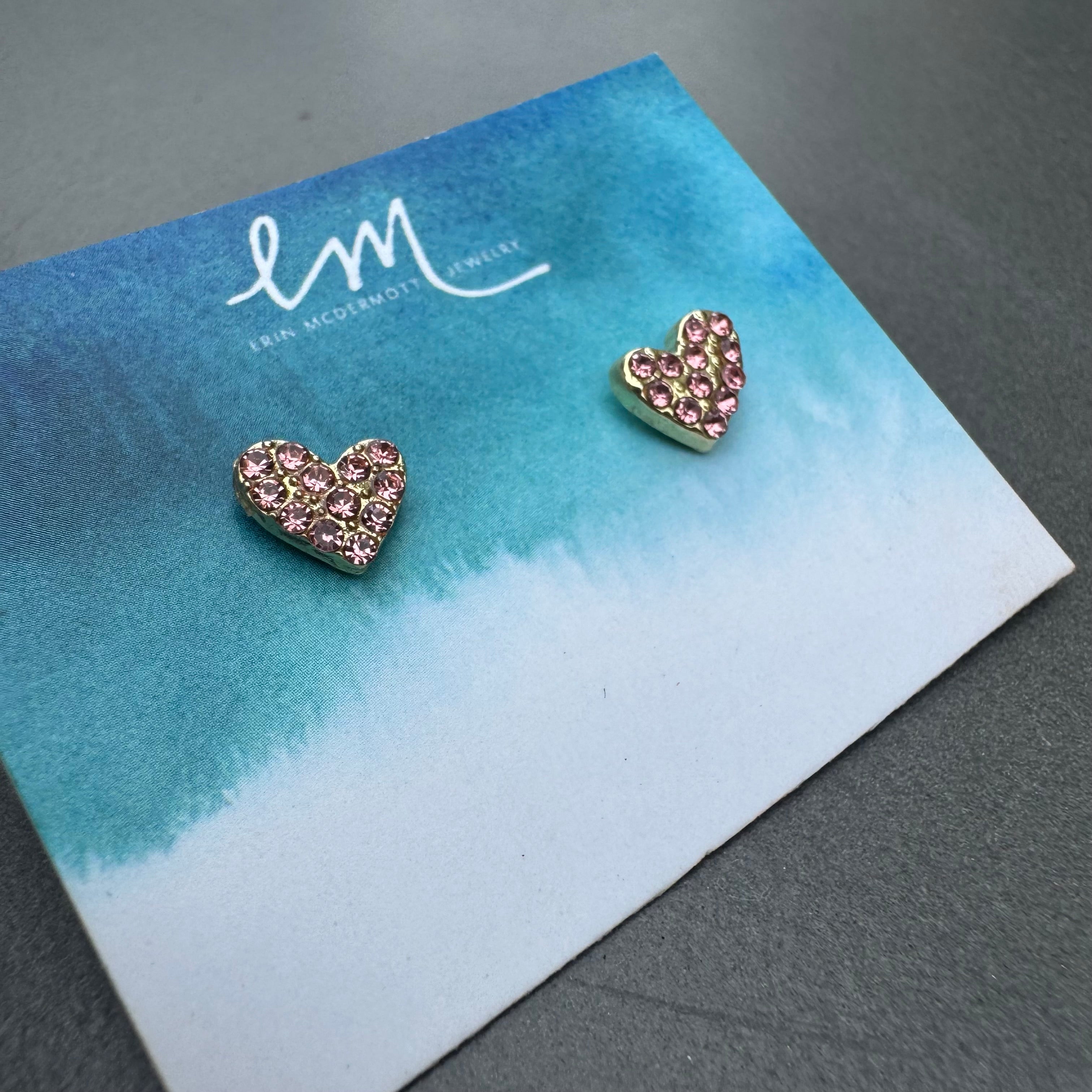 Heart-shaped earrings with pink stones on a branded card