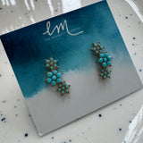 Turquoise earrings on a branded card with a blue and white gradient background