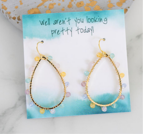 Large gold tear drop earrings with tiny beads ringing them. Beads are in yellow, white, blue and purple.