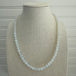 Picture of a bead necklace made up of opaque white beads.