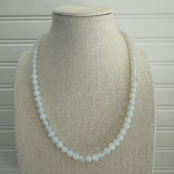 Picture of a bead necklace made up of opaque white beads.