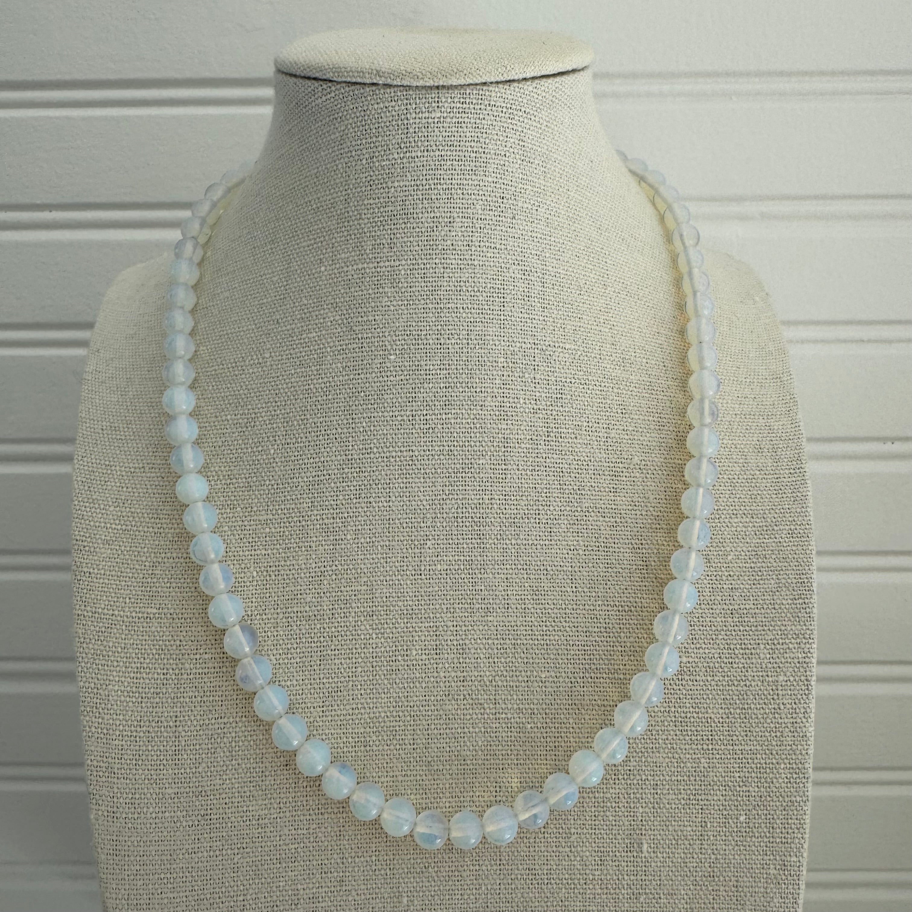 Picture of a bead necklace made up of opaque white beads.