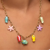 This image features a vibrant and colorful ocean charm necklace, displayed on a model. The necklace is crafted with a shiny gold-tone chain and is adorned with an array of bright, ocean-themed charms.