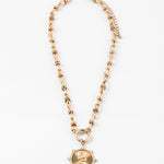 Gold necklace with a large gold clasp and a circular textured pendant on a white background