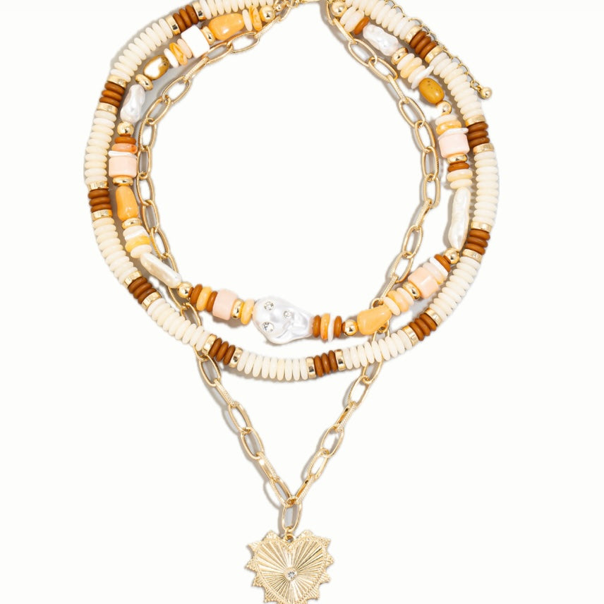 Set of layered necklaces with beaded and chain designs on a white background