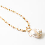 Large linked gold chain with a toggle clasp and a large pearlescent shell pendant.