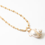 Large linked gold chain with a toggle clasp and a large pearlescent shell pendant.