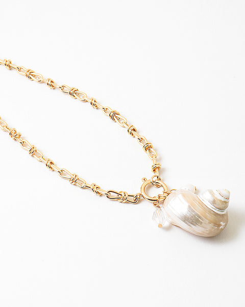 Large linked gold chain with a toggle clasp and a large pearlescent shell pendant.