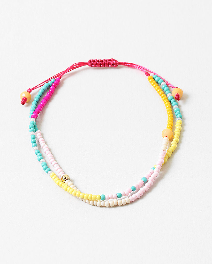 Bracelet made of double strands of beads in pinks, teals, whites and yellows.