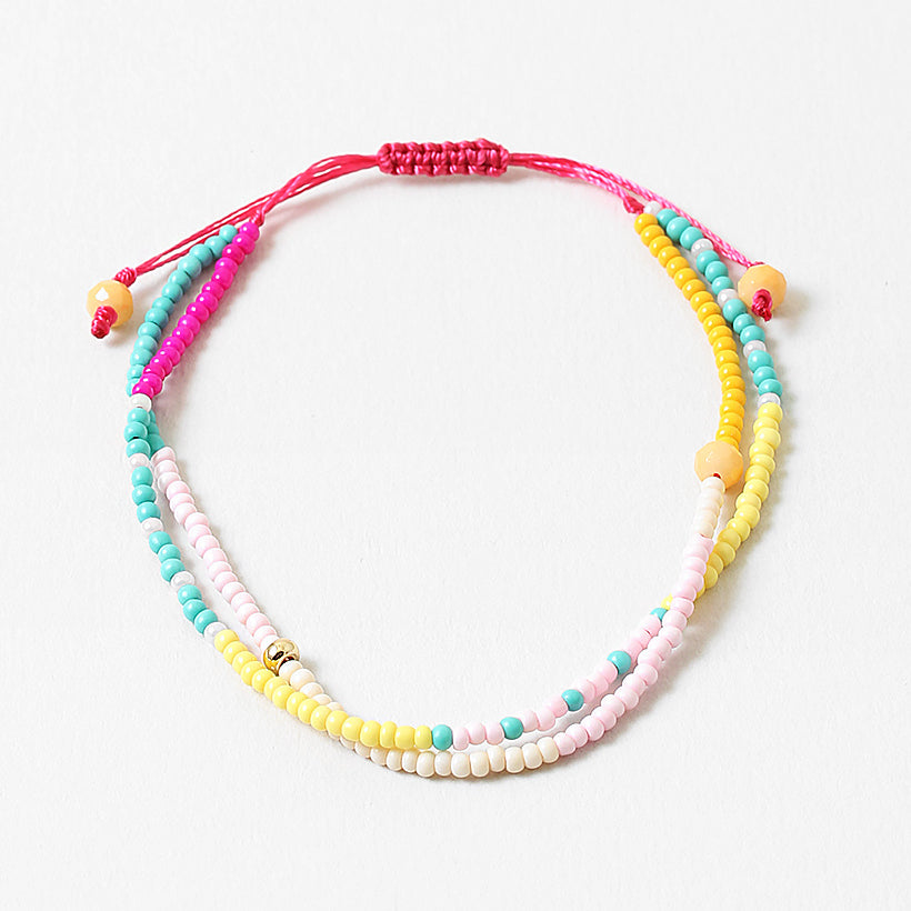 Bracelet made of double strands of beads in pinks, teals, whites and yellows.