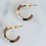 Small gold hoops with white and light brown resin accent sections.