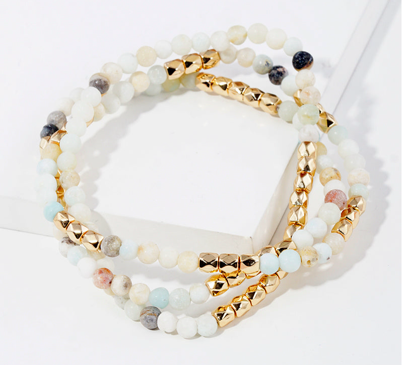 Set of semi precious white, grey and teal bead bracelets with gold accent beads.