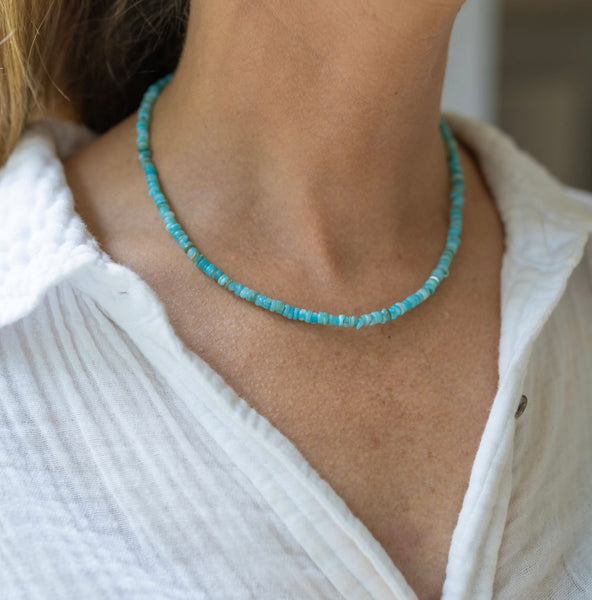 Woman wearing a tiny blue beaded choker 