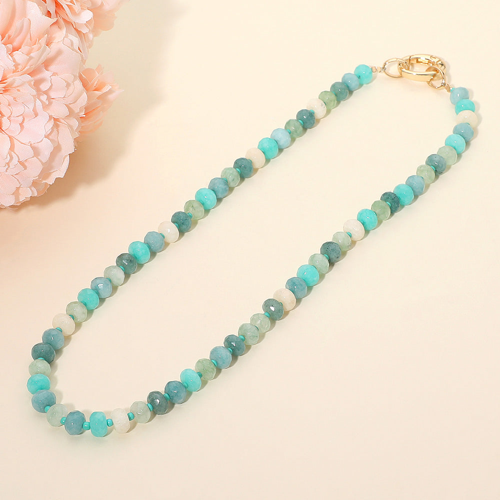 Necklace with blue and green beads on a light background