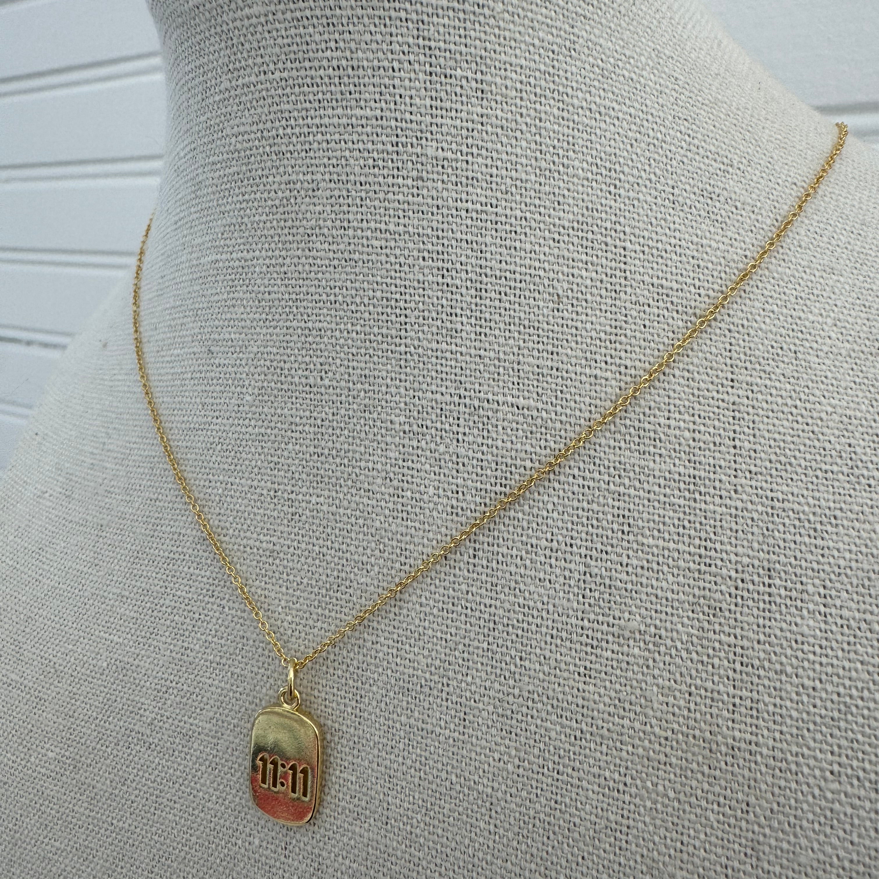 Picture of a dainty gold chain and a gold 11:11 charm