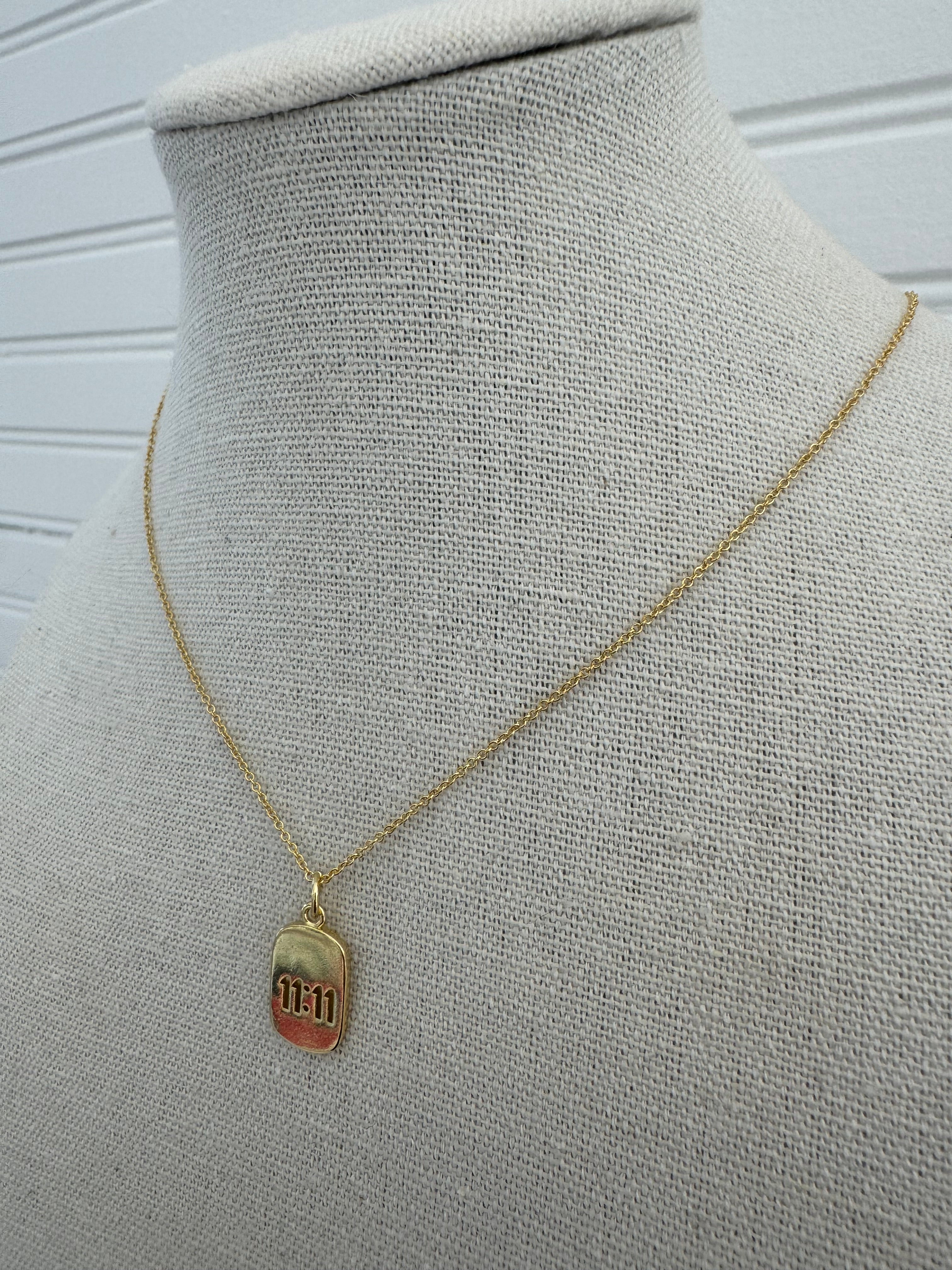 Picture of a dainty gold chain and a gold 11:11 charm