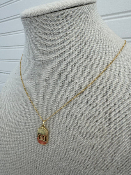 Picture of a dainty gold chain and a gold 11:11 charm