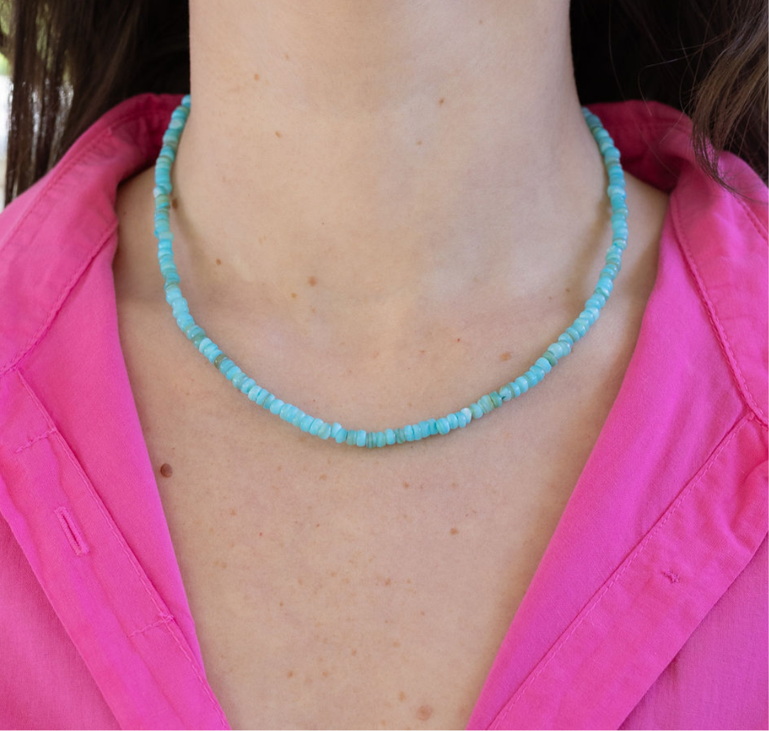Graphic of woman's neck wearing a blue bead necklace.