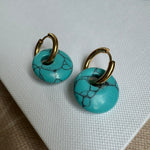 Small gold hoop threaded through a turquoise disc bead.