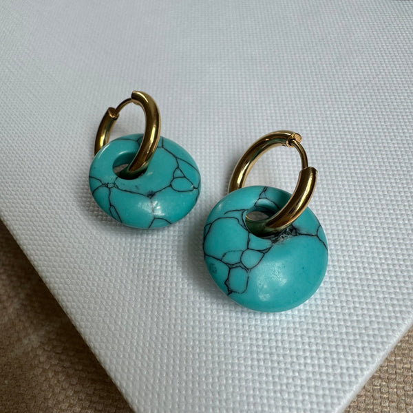 Small gold hoop threaded through a turquoise disc bead.