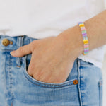 Picture of a woman wearing a beaded bracelet in shades of light blues, pinks and yellows