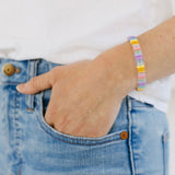 Picture of a woman wearing a beaded bracelet in shades of light blues, pinks and yellows