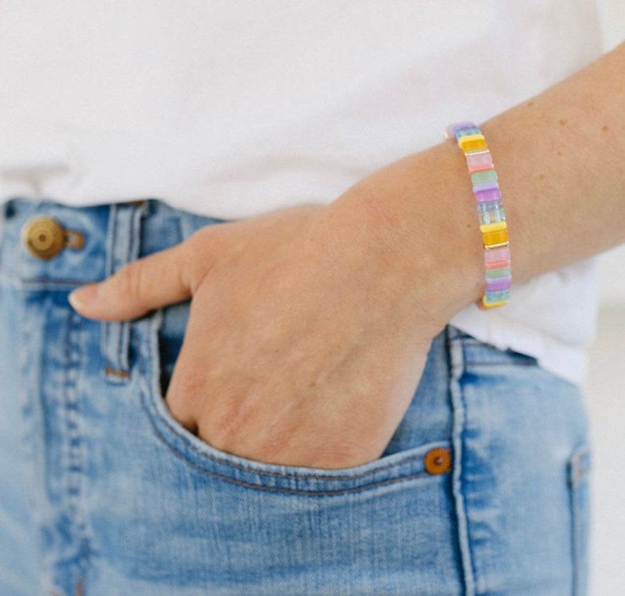 Picture of a woman wearing a beaded bracelet in shades of light blues, pinks and yellows