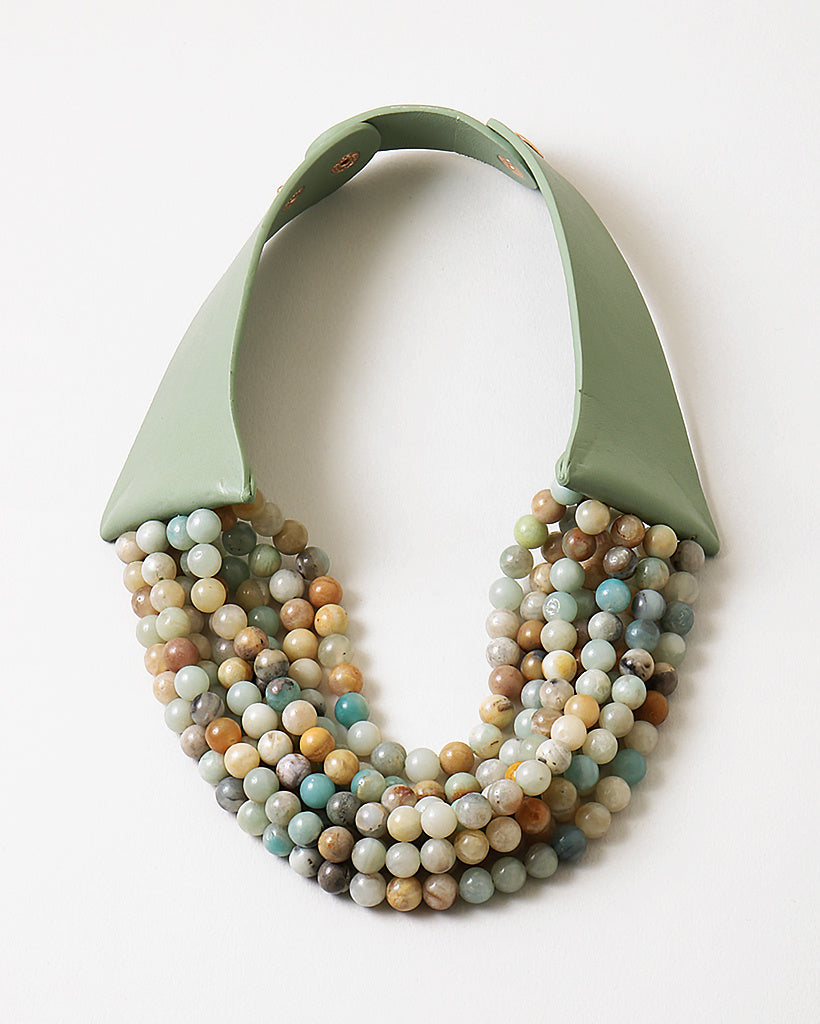 Picture of a six strand semi precious Gemstone beaded bracelet in earthy tones with a green leather strap.