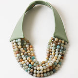 Picture of a six strand semi precious Gemstone beaded bracelet in earthy tones with a green leather strap.