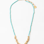 Blue bead necklace with gold beads at its center and a gold clasp.