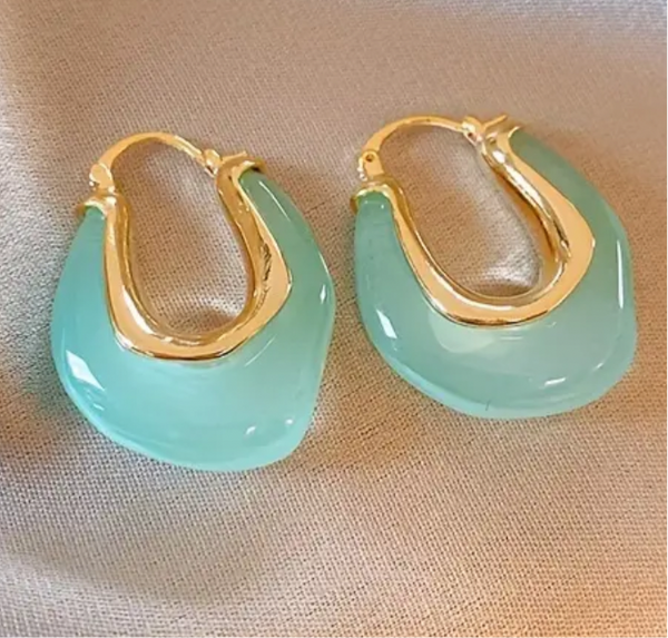 Picture of a set of earrings that are sea green hoops with gold insides.