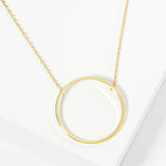 Gold necklace with a circular pendant on a white background