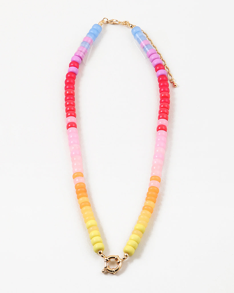Picture of bead necklace in pinks, reds and yellows with a gold toggle clasp.