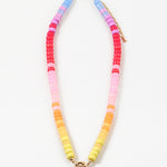 Picture of bead necklace in pinks, reds and yellows with a gold toggle clasp.