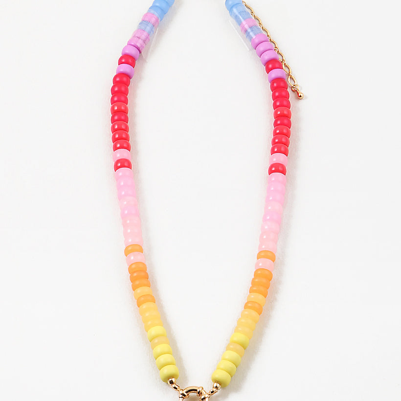 Picture of bead necklace in pinks, reds and yellows with a gold toggle clasp.