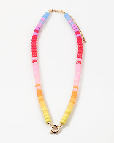 Picture of bead necklace in pinks, reds and yellows with a gold toggle clasp.