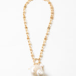Large linked gold chain with a toggle clasp and a large pearlescent shell pendant.