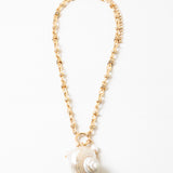 Large linked gold chain with a toggle clasp and a large pearlescent shell pendant.