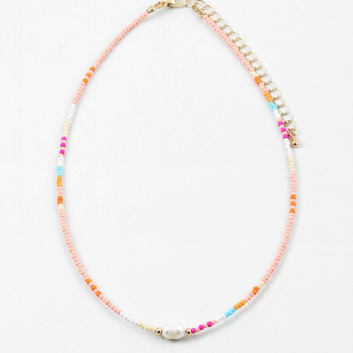 Necklace with multicolored beads in pinks, blues and whites with a freshwater pearl on a white background