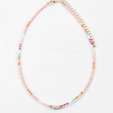 Necklace with multicolored beads in pinks, blues and whites with a freshwater pearl on a white background