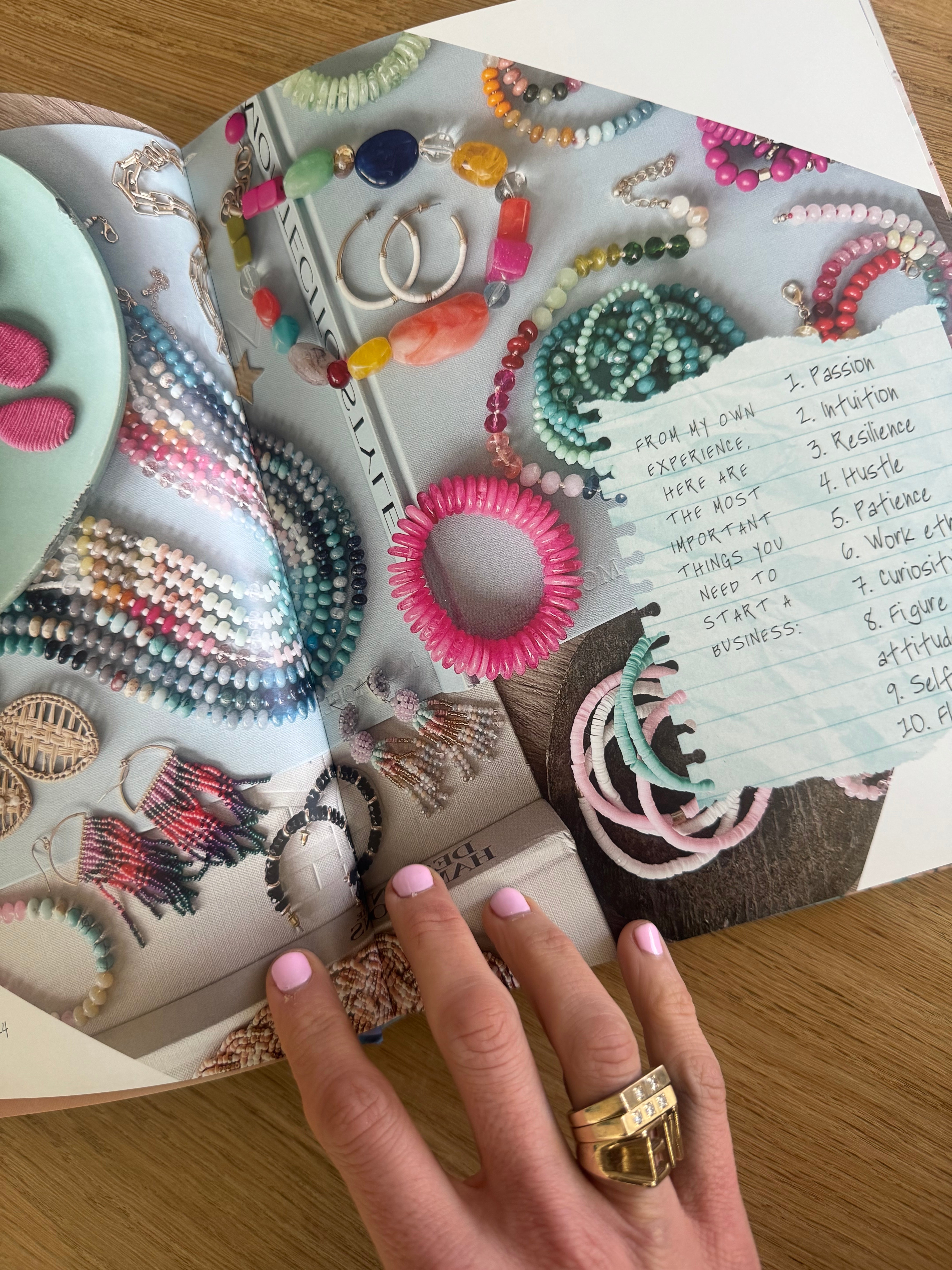 Hand holding open a magazine with a picture of colorful beaded jewelry and a handwritten note with a list outlining what things your need to start your own business.