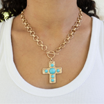 Large gold circle link chain with a toggle clasp and a large gold Cross with turquoise stones.